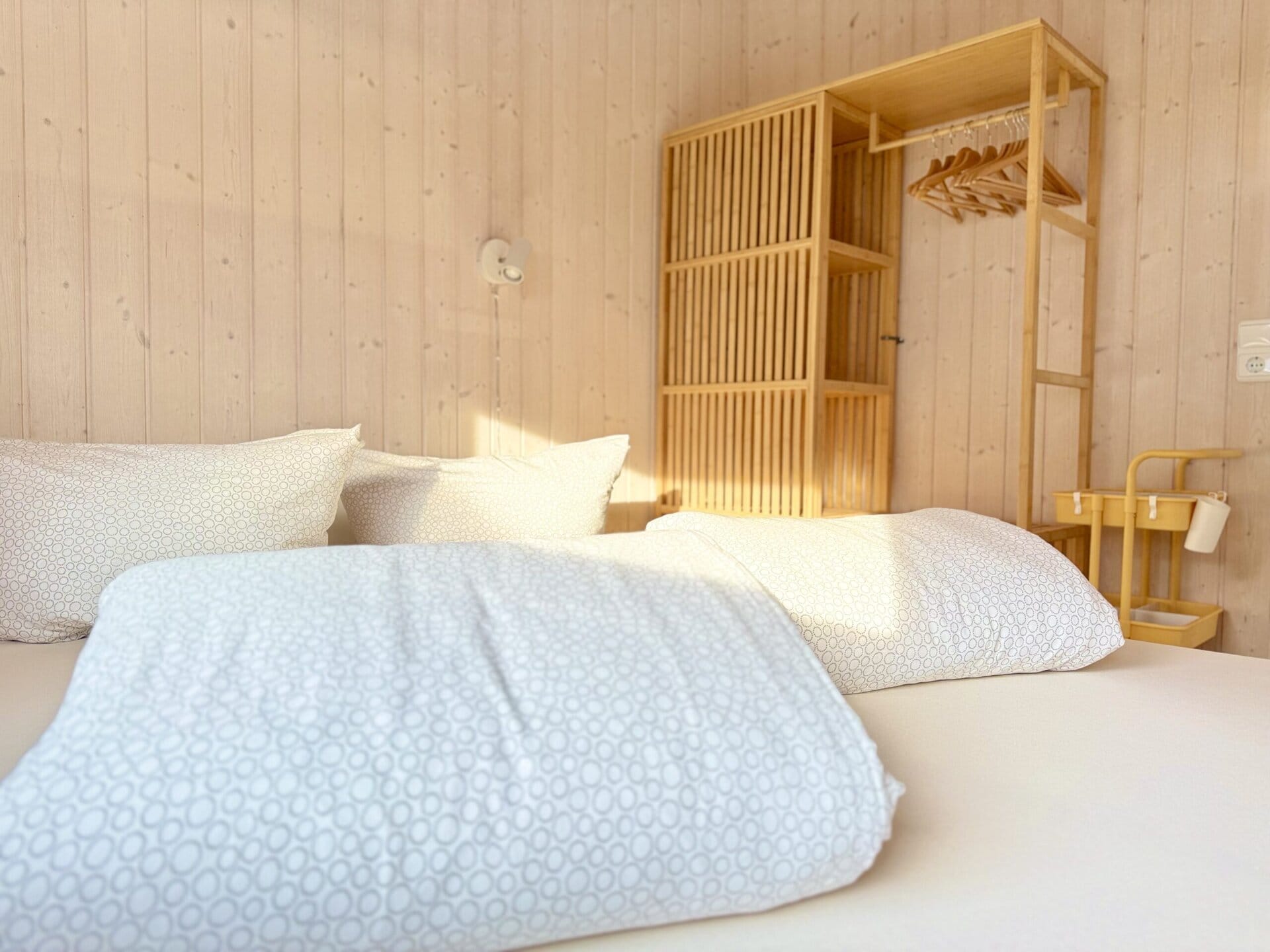 Bett im modernen Holzdesign, gemütliches Schlafzimmer, natürliche Einrichtung, MV Urlaubsgestaltung.