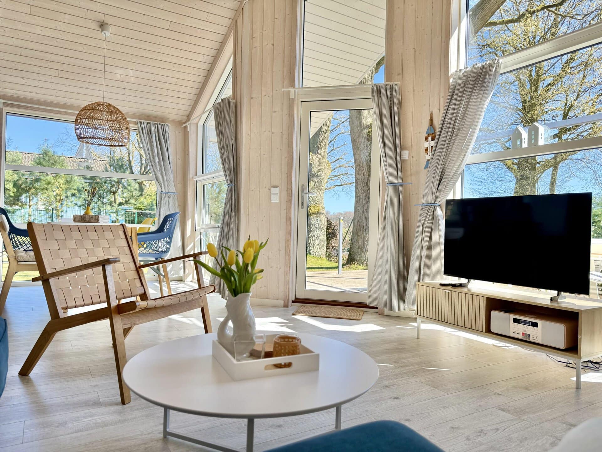 Gemütliches Wohnzimmer mit großen Fenstern und moderner Einrichtung.