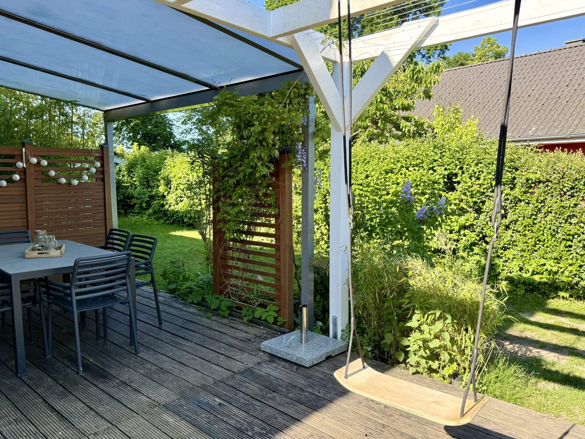 IMG_8013 Gemütlicher Garten mit Sitzbereich, Sonnenschirm und grüner Natur, ideal für Entspannung.
